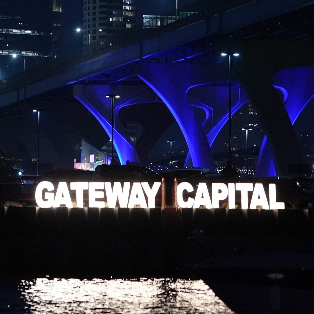 Illuminated Gateway Capital sign against the Milwaukee skyline at night